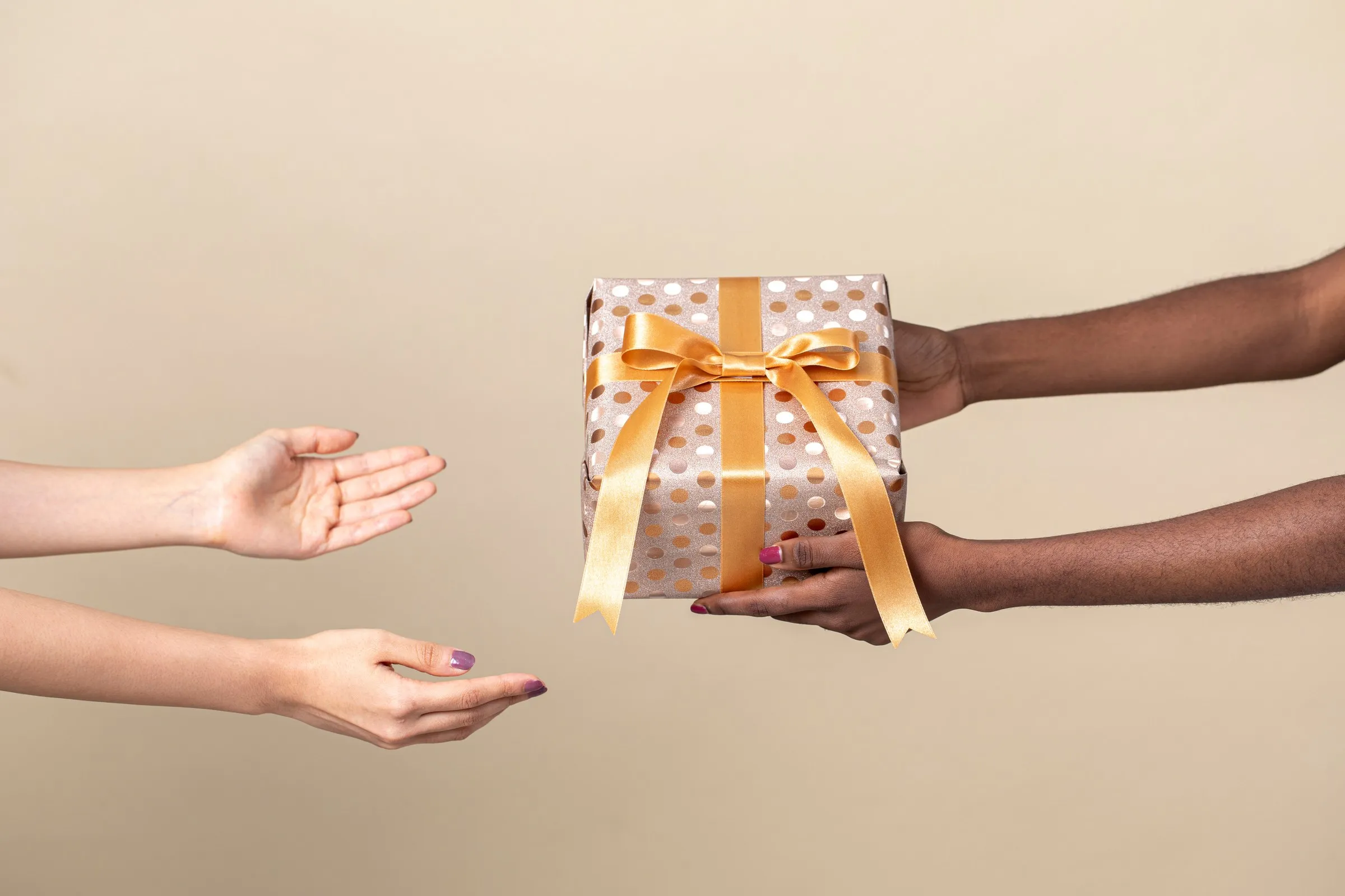 A wrapped gift being handed from one person to another