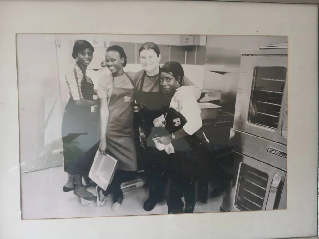 Framed archive photo of four staff members standing in a commercial kitchen